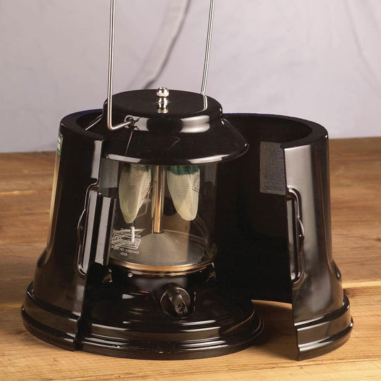 Black camping lantern on a wooden surface with a neutral background