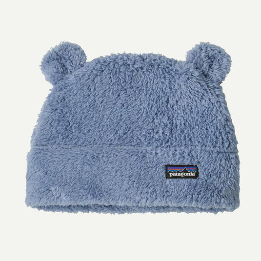 Blue fuzzy baby hat with bear ears and Patagonia logo on a light gray background