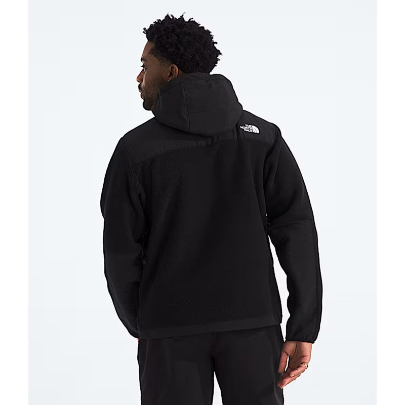 Load image into Gallery viewer, Person wearing a black hoodie with a brand logo on the back against a white background
