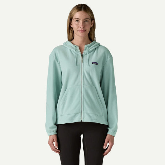 Woman wearing a light blue hoodie with a brand logo on a white background