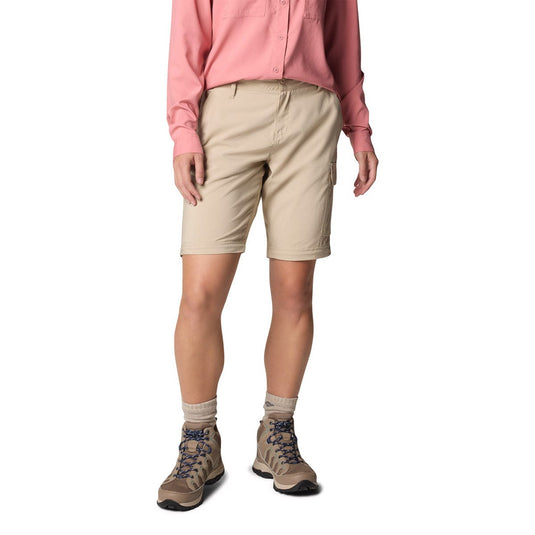 Person wearing beige shorts, pink shirt, and hiking boots on a white background