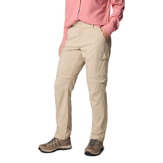 Person wearing beige cargo pants with a pink shirt on a white background